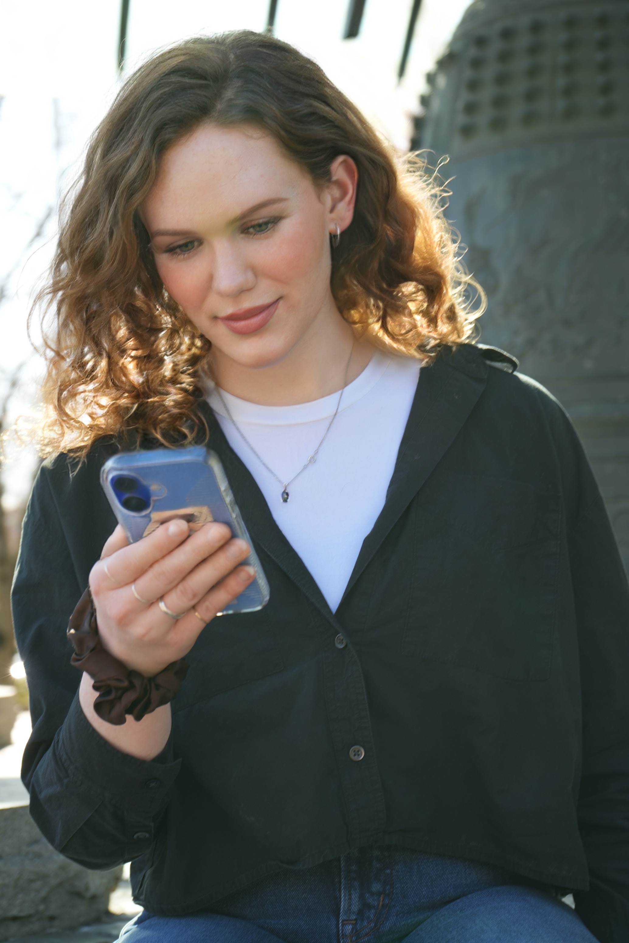 A person checking Hormone Helper on their phone outdoors
